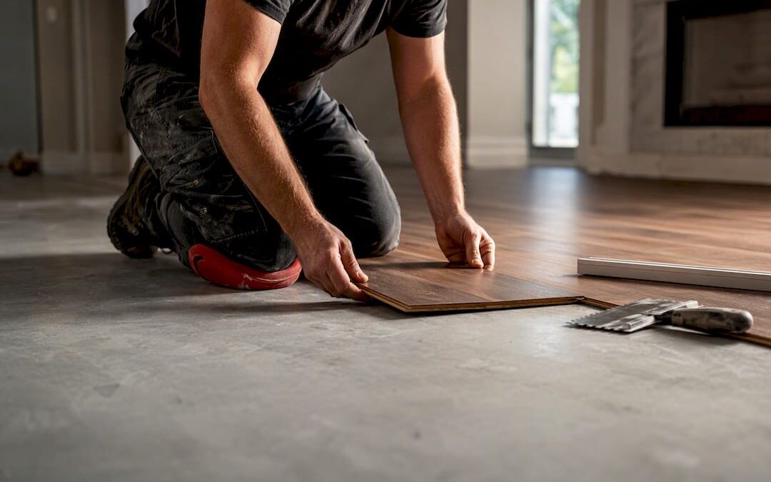 Installer positioning hardwood over concrete slab